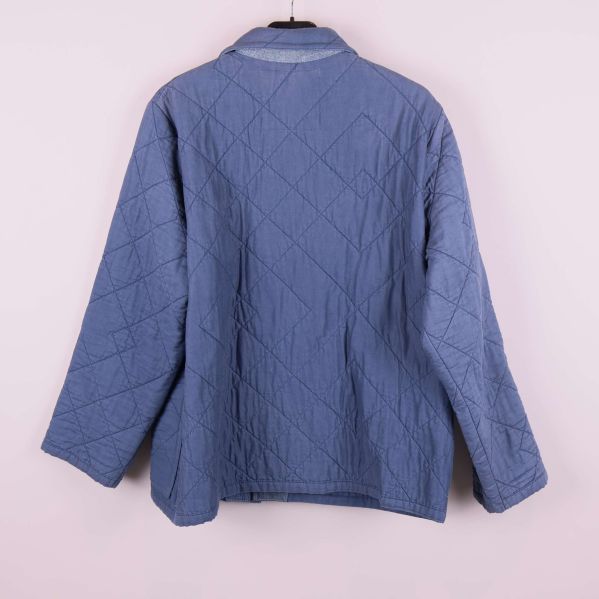 Blå quiltad jacka sedd bakifrån, visar detaljer och passform