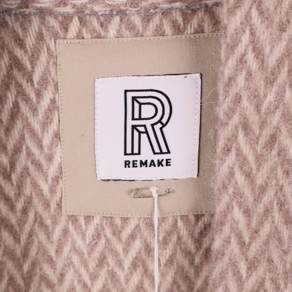 Närbild på tygmärke med Remake-logotyp i kragen