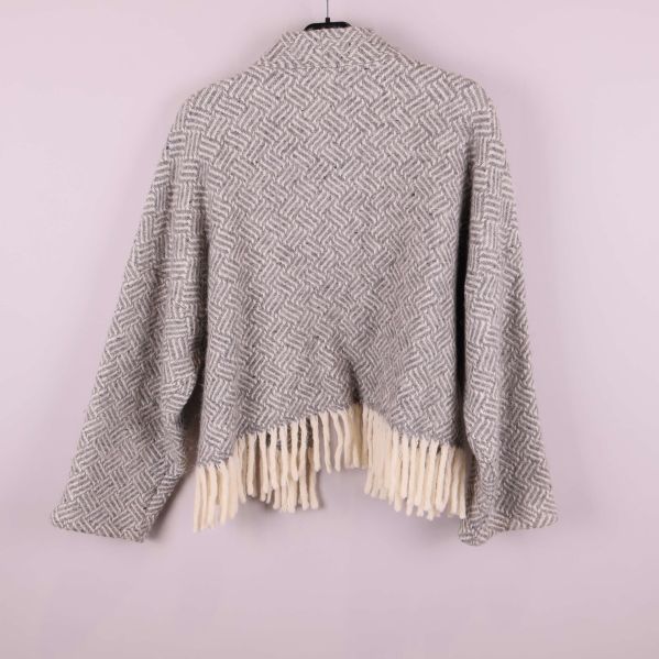 Baksidan av jacka med fransar och mönstrat tyg visas på galge