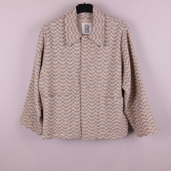 Jacka i vågmönstrat tyg upphängd på galge