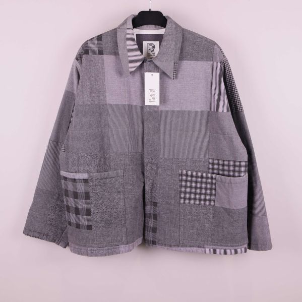 Grå patchwork jacka framifrån på galge