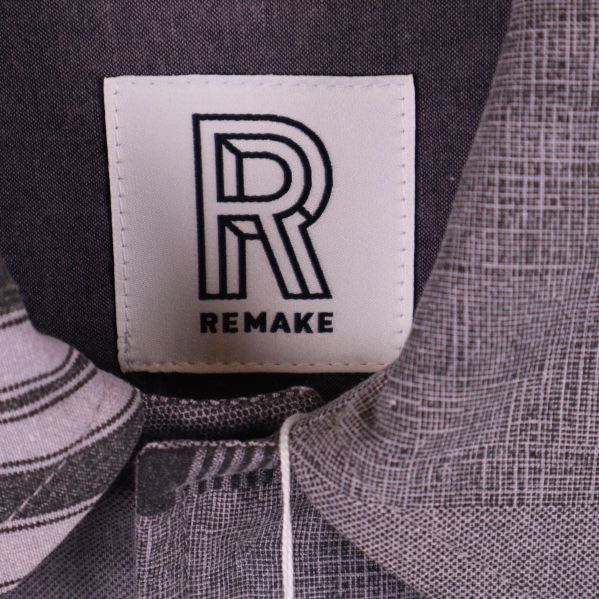 Närbild av Remake-logotyp på jackans etikett