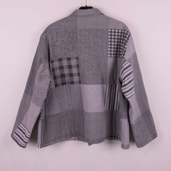 Baksidan av grå patchwork-print jacka syns tydligt