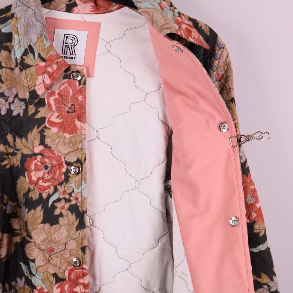 Insida av jacka med rosa foder och knäppning