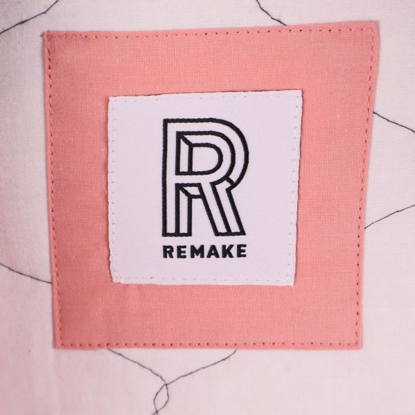 Remake-logga på rosa tygbit inuti jackan