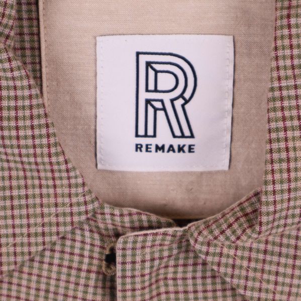 Närbild på logotypen Remake i jackans halsringning