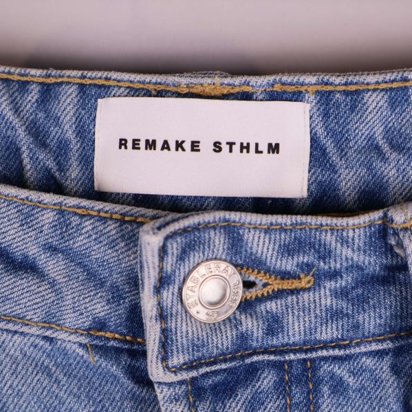 Etikett med Remake STHLM i midjan på jeansen