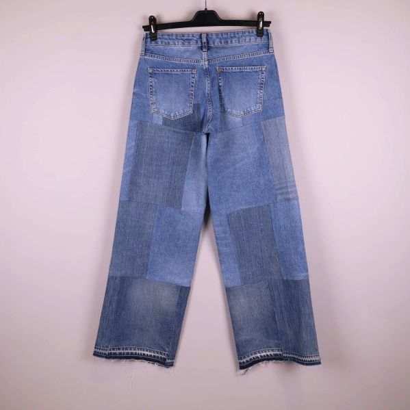 Baksida av patchwork jeans med bakfickor