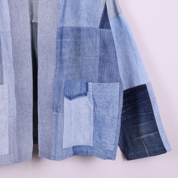 Närbild på jackans fickor och ärm i denim patchwork