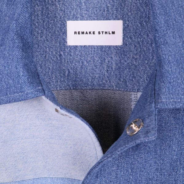 Närbild på krage och knapp i denimjacka