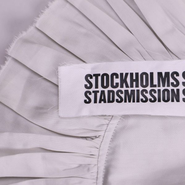 Närbild på textetikett med Stockholm Stadsmission-logga