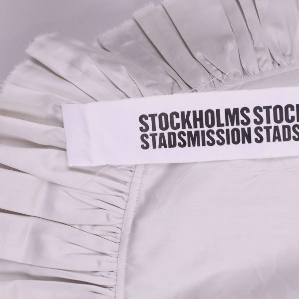 Textband med svart tryck på vit tygväska