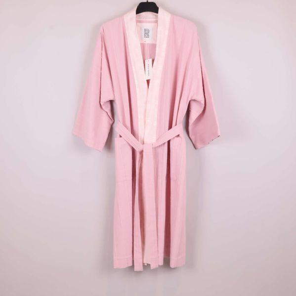 Rosa kimono med bälte hängande på galge