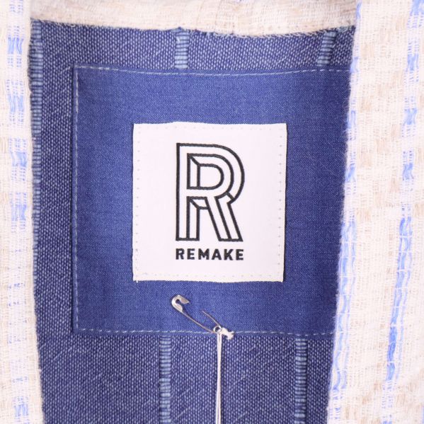 Logotypetikett med texten Remake på insidan