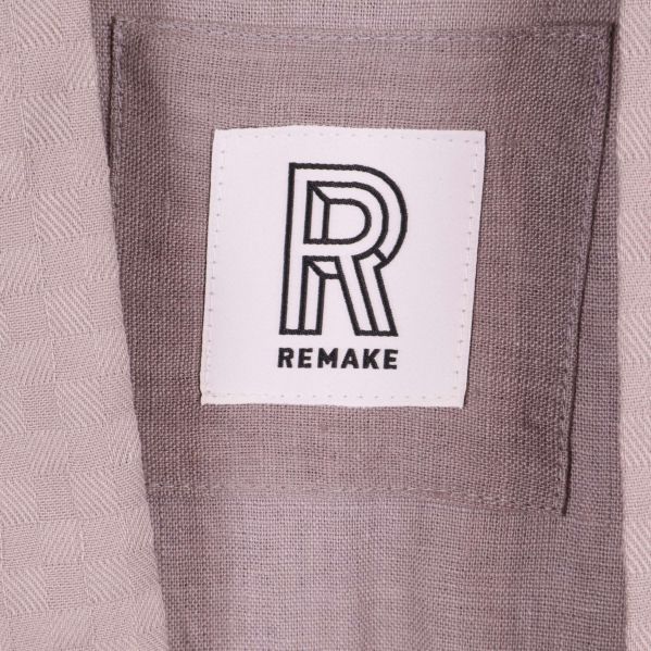 Närbild på Remake-logotypen på fickan av kimono