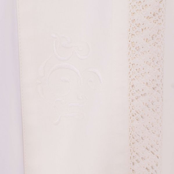 Detaljbild på broderi och spets på skjortans framsida