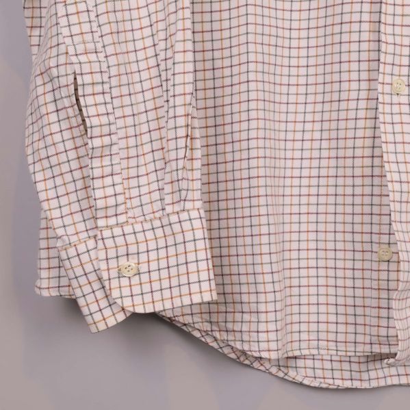 Detalj av skjortans ärmslut och rutigt tyg