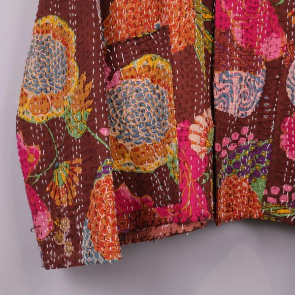 Närbild på ärmslut och tyg med broderade detaljer