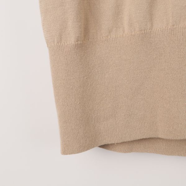 Nedre delen av beige polotröja