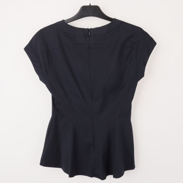 Baksida av blus med synlig dragkedja och nätt passform