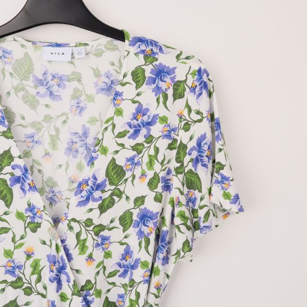 Närbild på blommigt mönster och halsringning
