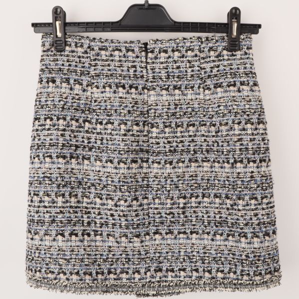 Baksidan av en flerfärgad tweedkjol med dragkedja