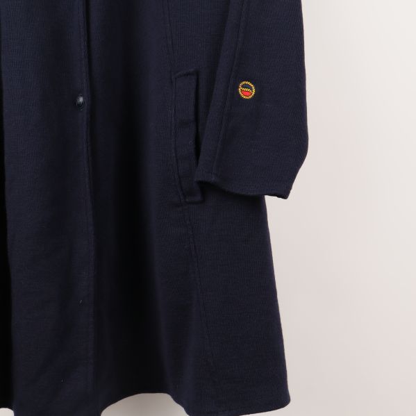 Närbild av kappärm med broderad logo