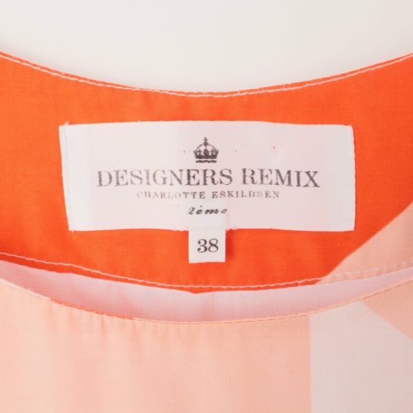 Närbild på tunikans etikett: Designers Remix 