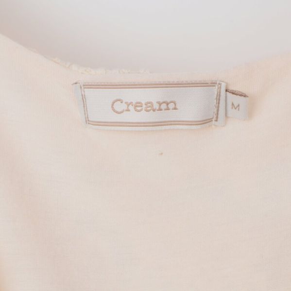 Närbild av Cream etiketten och storlek M