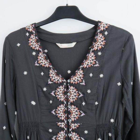 Närbild på broderade detaljer vid halsen