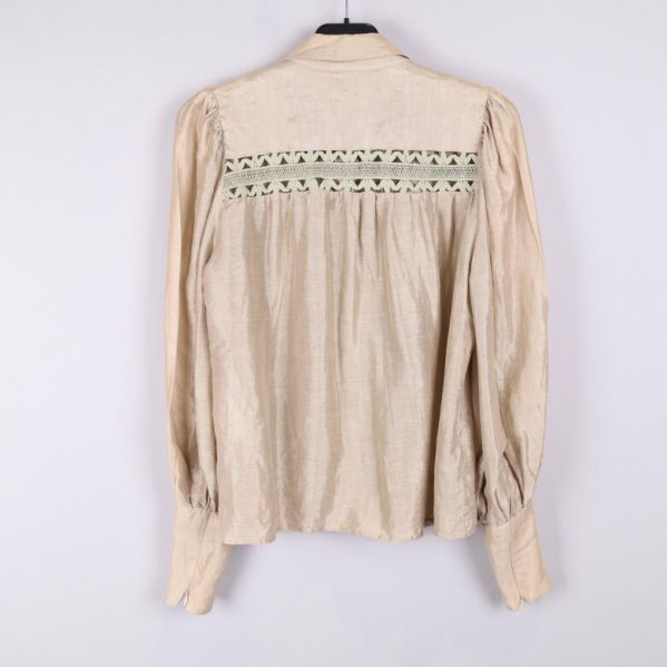 Baksidan av beige blus med spetsdetaljer