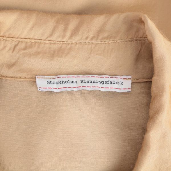 Närbild av etikett från Stockholms Klänningsfabrik
