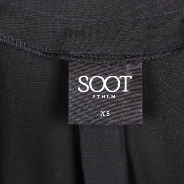 Närbild av klänningens etikett med storlek: XS