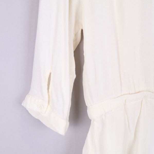 Närbild av blusens ärm med knapp