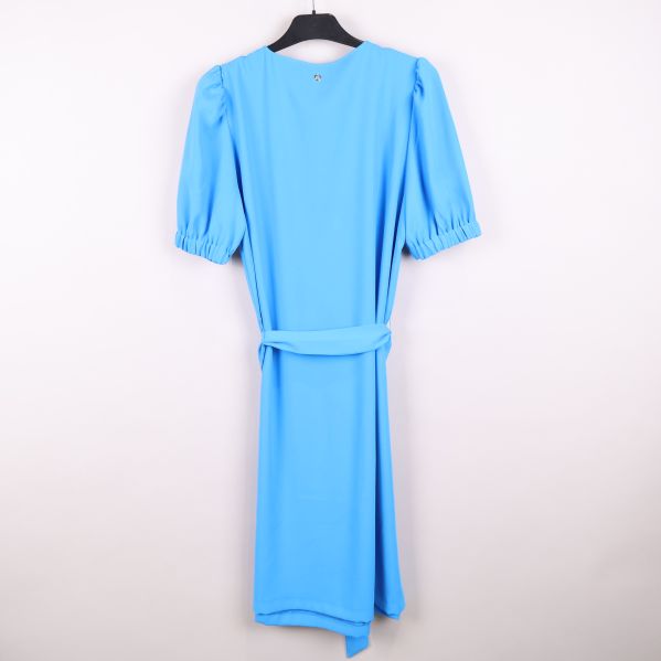 Baksidan av blå klänning med detalj på knäpp