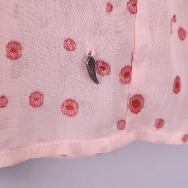 Detalj av metallberlock på blusen