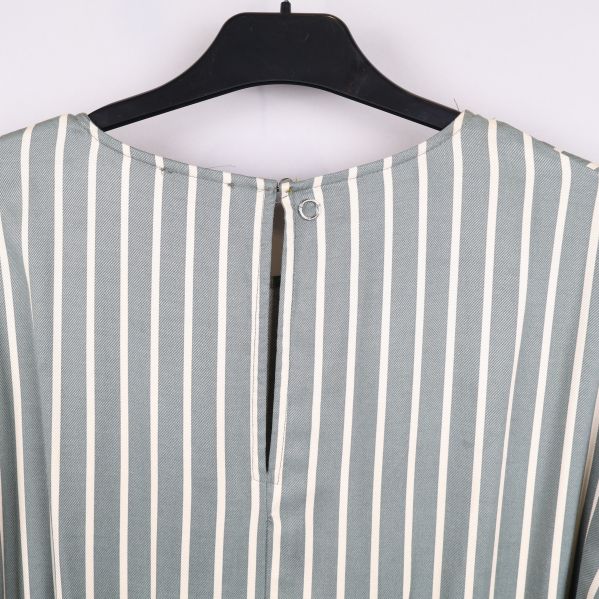 Närbild på knapp i nacken på randig klänning