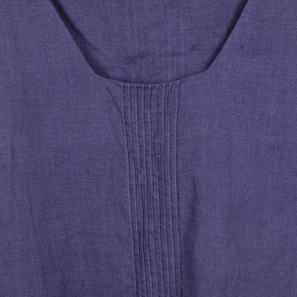 Närbild på veckdetalj på blå blus