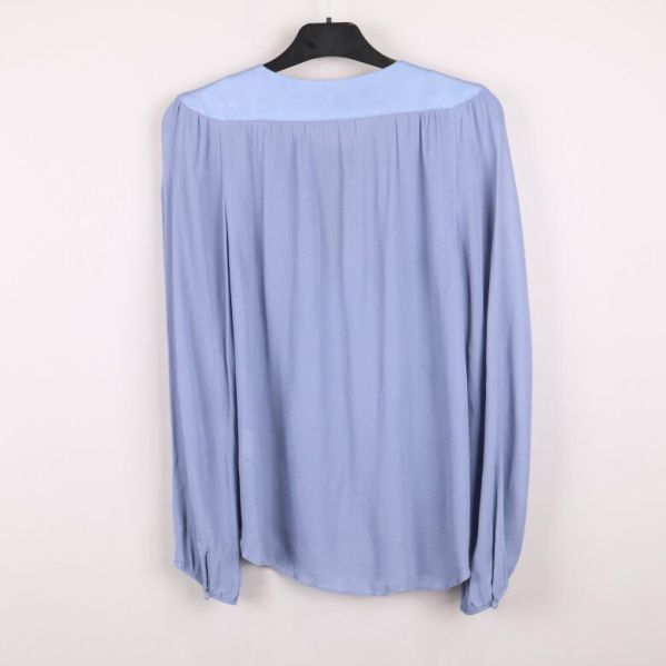 Baksidan av blå blus med långa ärmar