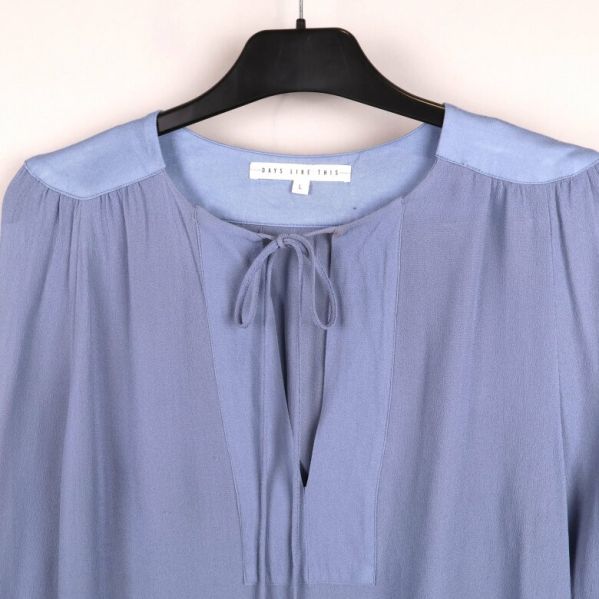 Närbild av blusens knytdetalj och linning