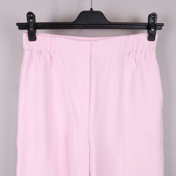 Närbild på resårmidja på rosa byxor