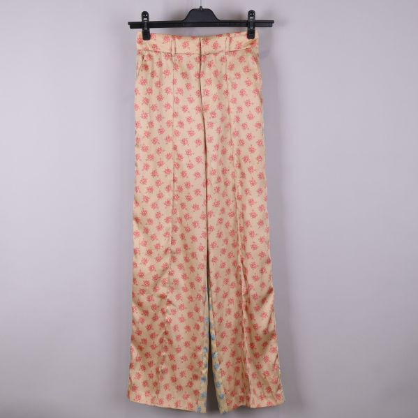 Framsida av blommiga byxor i beige och röd