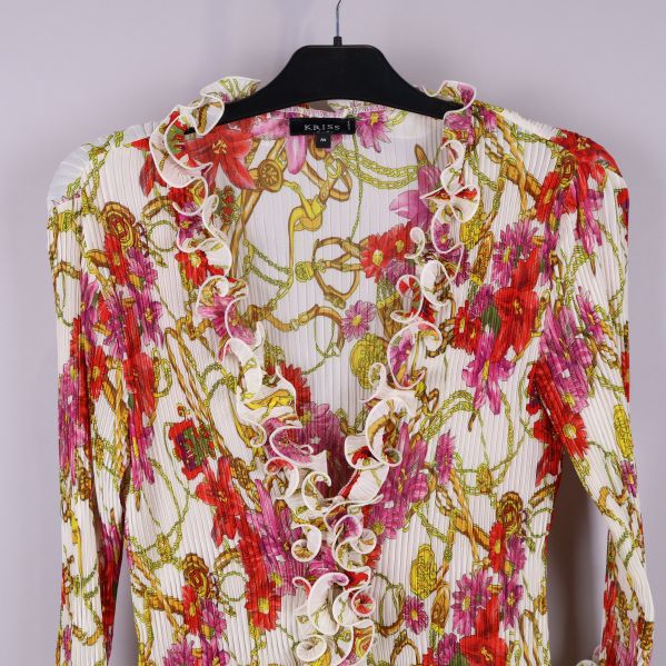 Närbild av blus med rysch och blommor