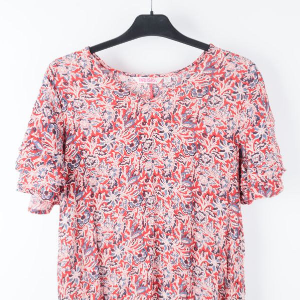Närbild av klänningens blommiga mönster på byst