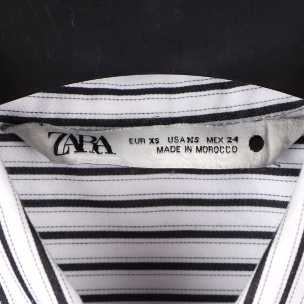 Närbild av ZARA-märket i skjortkragen