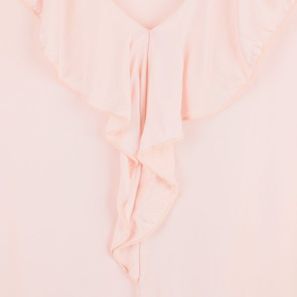 Närbild på blusens framsida med volangdetaljer