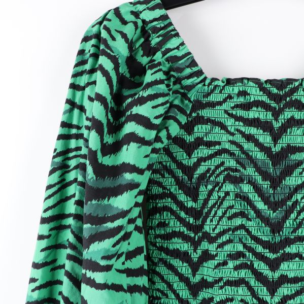 Ärm med mönsterdetaljer Ärmdetalj på grön blus med mönster