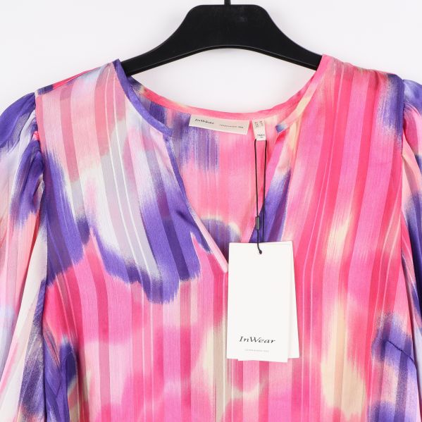 Detaljbild av blusens mönster och produktlapp