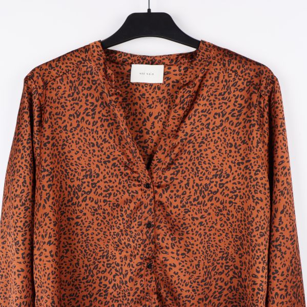 Närbild på leopardmönstrad blus med etikett