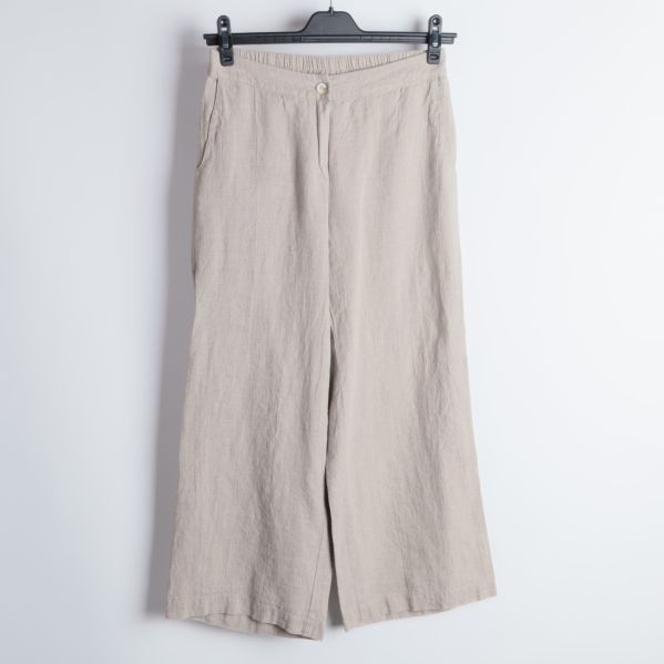 Främre delen av beige byxor med knapp.
